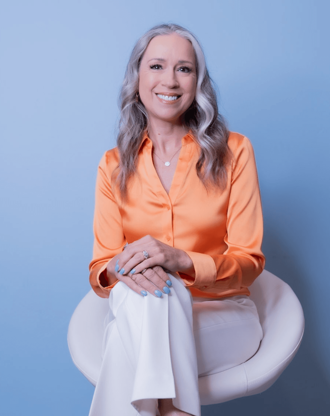 Portrait of Gina Van Luven, Board-Certified Health Coach and owner of Prime IV Mesa, seated against a soft blue backdrop